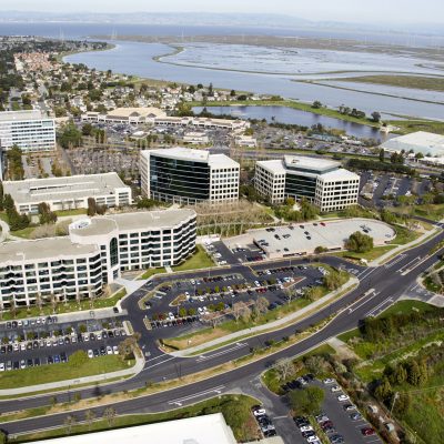 Aerial photography view photograph north-east of Redwood Shores in the San Francisco Bay Area. The picture includes coporate buildings of EndoGastric Solutions inc., Jolly Technologies Inc., Weil Gotshal & Manges inc.. Also the Steinberger Slough inlet and The Twin Dolphin Drive road is visible. Redwood City, CA 94065.